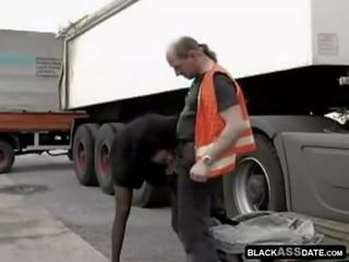 Negra streetwalker cabalgando en madura truck conductor fuera